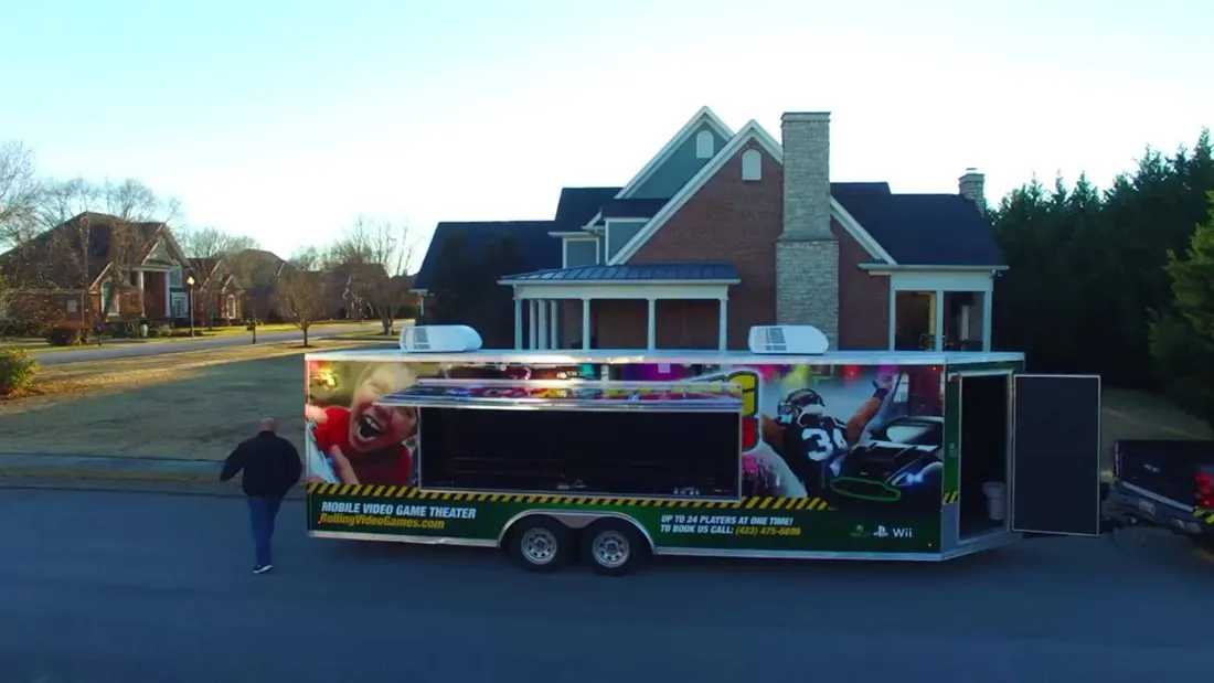 Mobile game trailer parked with an exterior screen open